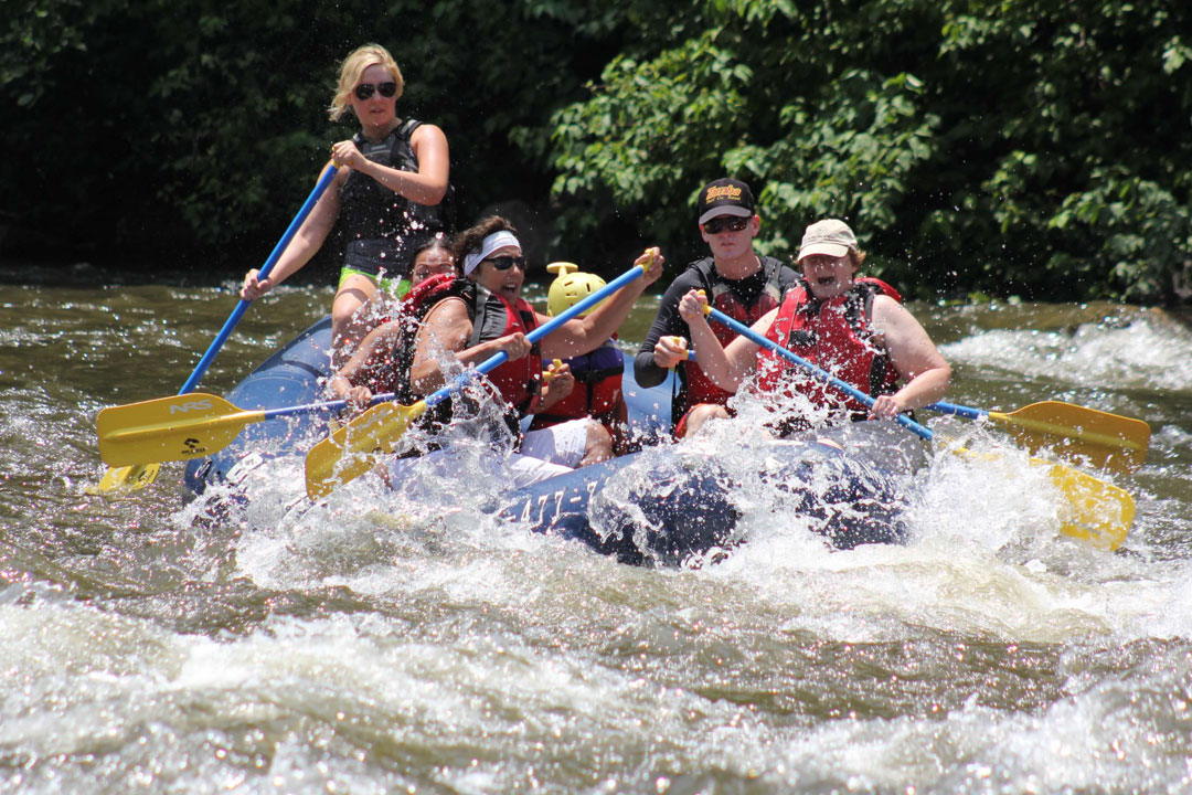 group of people white water rafting