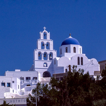 photo of white washed church with blue dome and pyramidal bell tower