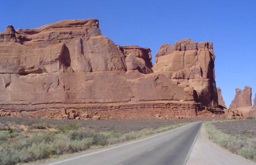Road going up to large sandstone formation in one of six national parks of the southwest