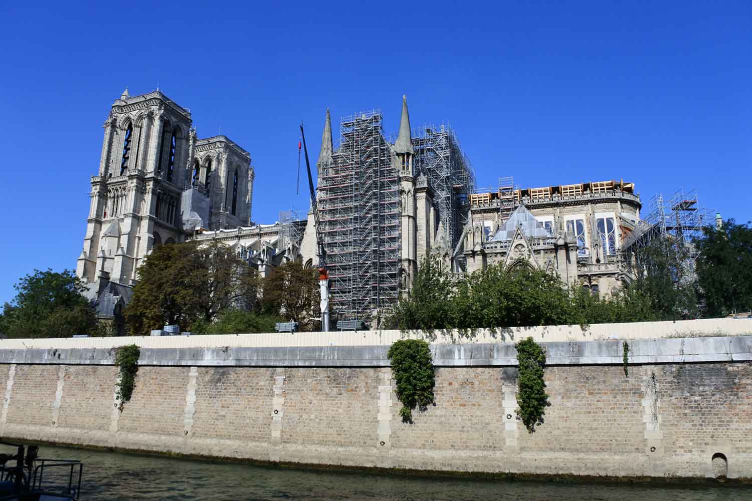 Scaffolding surrounding a large cathedral located along a river