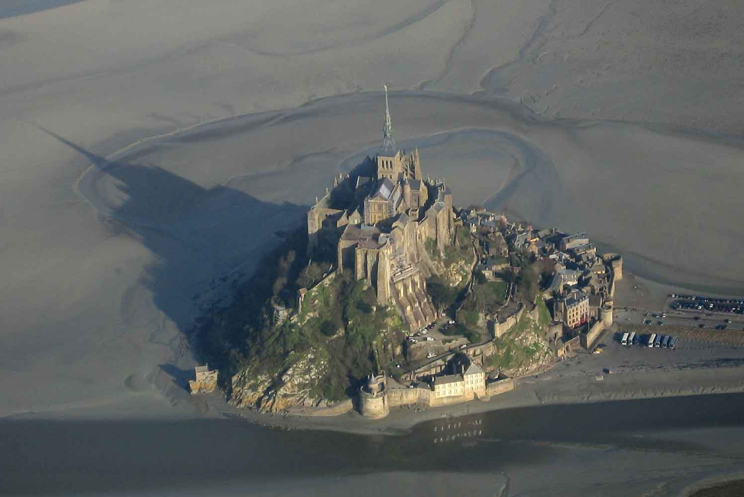 aerial photo of an island surrounded by sand while the tide is out