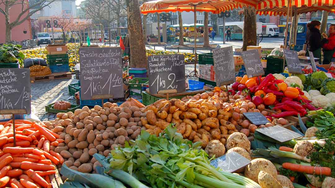 Example of a market in Europe. Lots of colorful vegetables arranged on a table with signs marking the prices