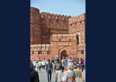 Red sandstone walls with a gate in front. Lots of tourists milling about.
