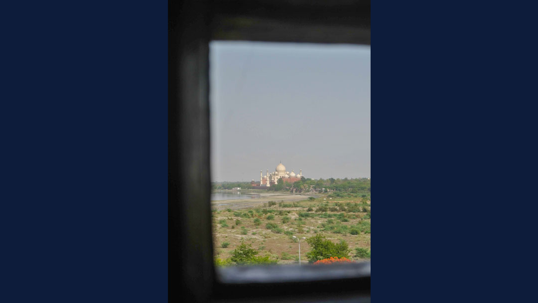 Taj Mahal shown in the distance through a very narrow opening