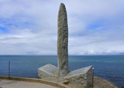 large roughly carved sword made of granite overlooking the sea