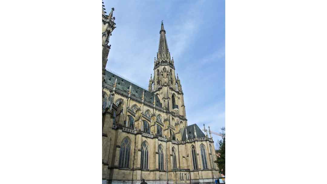 Photo of large church with single tall spire.