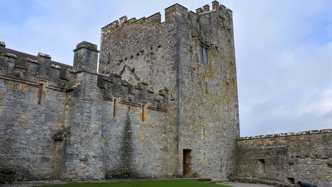Inside courtyard with stone walls and a stone tower of Cahir Castle, Cahir, Ireland