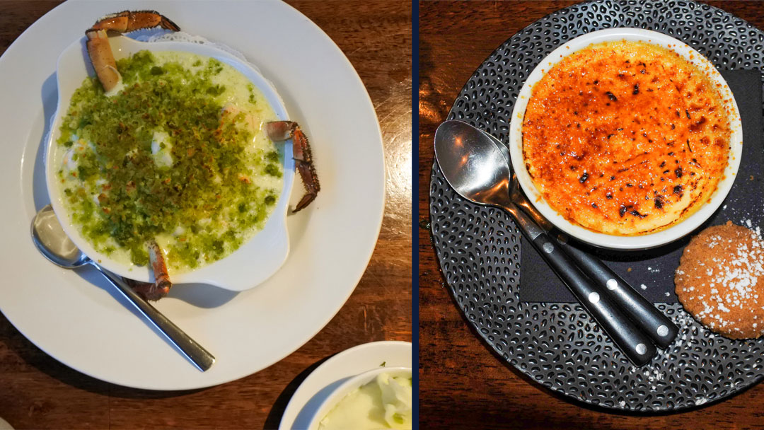 picture of two plates, one with a creamy looking liquid topped with greenish colored crumbles and with three crab's legs sticking out decoratively from the dish. The other plate has a bowl with a yellowish colored pudding with a browned top; two spoons and a cookie are also on the plate.