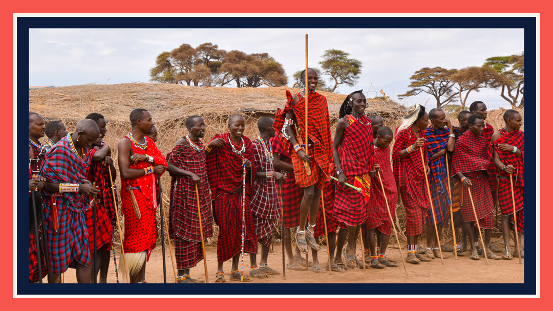 Maasai men standing together, one is jumping; a tradition of the Maasai cluture.