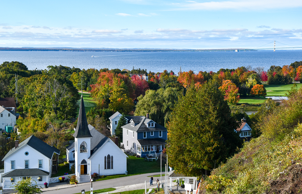 Looking down onto Spring St. from Ft. Mackinac, with fall colors on the trees, Lake Huron and the Mackinaw Bridge in the background.